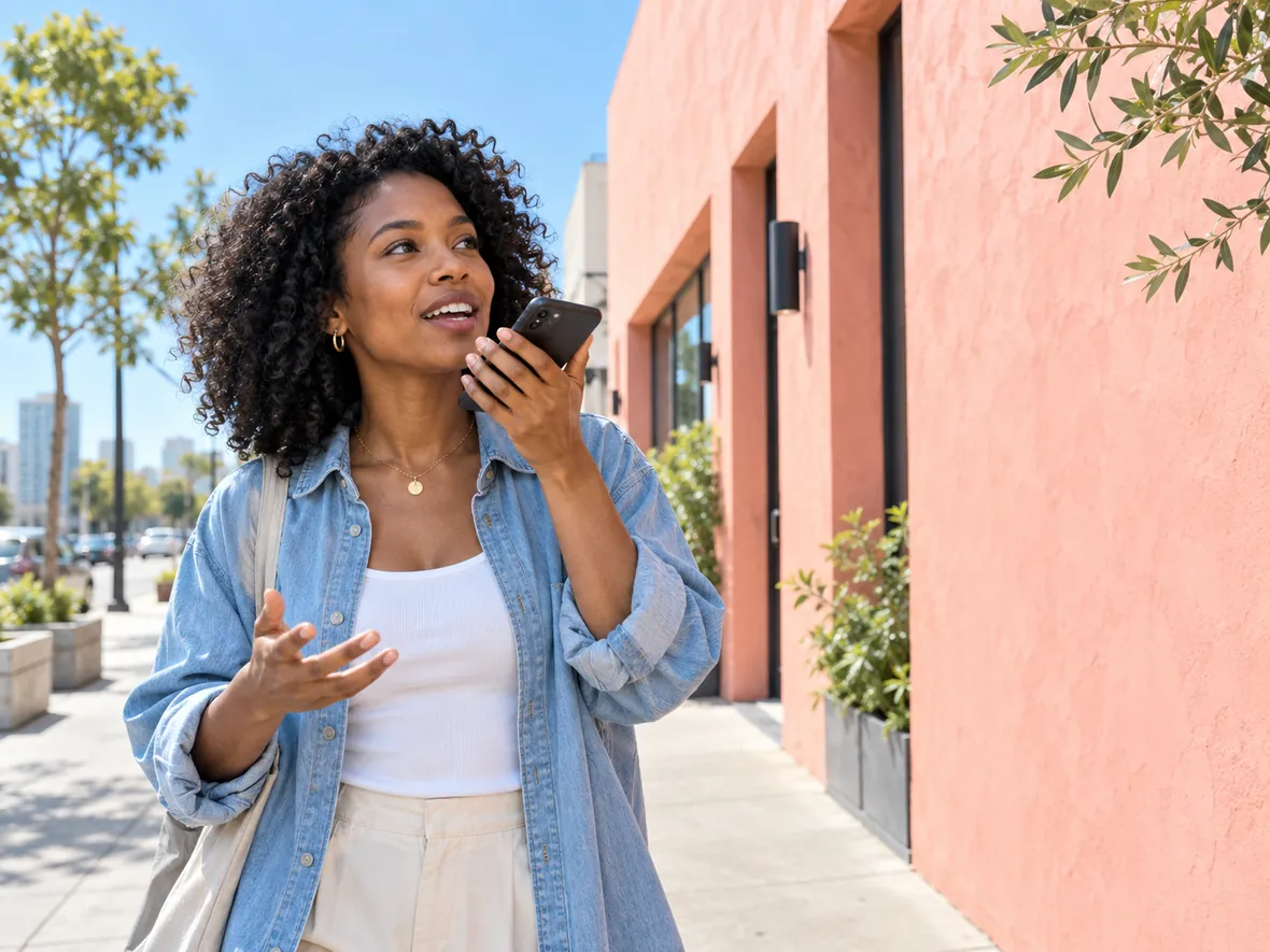 A woman recording a spontaneous voice note during a bright morning city walk